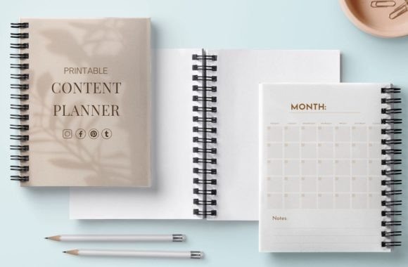 Printable monthly planner with calendar and content planner notebooks on a light blue background with pencils and a cup